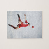 Voetbalspeler en voetbal in de lucht legpuzzel (Horizontaal)