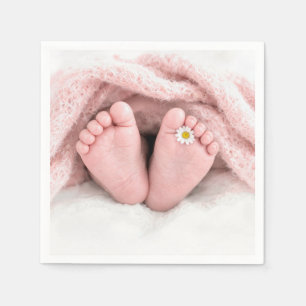 Voetjes van een babymeisje met een witte madeliefj servet