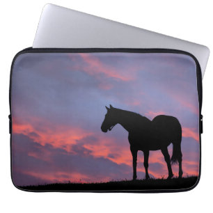 Volbloed paard afgetekend tegen de opkomende zon laptop sleeve