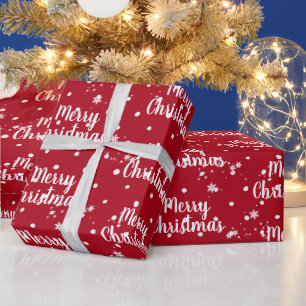 Vrolijk kerstbericht in sneeuwvlokken op rode vlok cadeaupapier