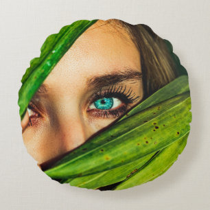 Vrouw achter groene bladeren rond kussen