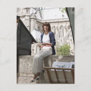 Vrouw die een boek leest in een boekenkraam, Notre Briefkaart