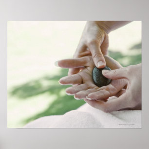Vrouw die handmassage krijgt met hete steen poster