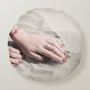 Vrouw die op wit zand ligt rond kussen