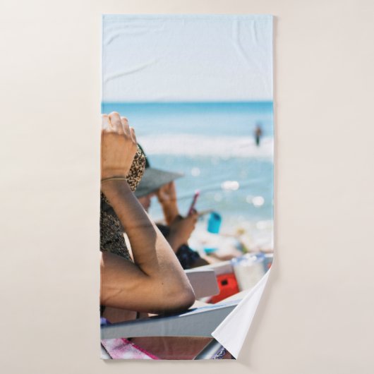 Vrouw die op zonlounger ligt en haar gezicht bedek badhanddoek (Badhanddoek)