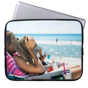 Vrouw die op zonlounger ligt en haar gezicht bedek laptop sleeve