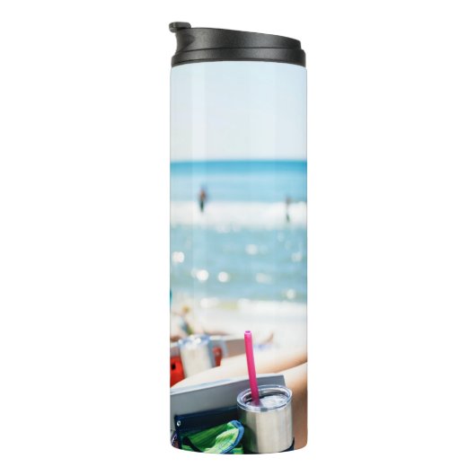 Vrouw die op zonlounger ligt en haar gezicht bedek thermosbeker (Geroteerd rechts)