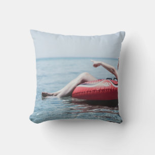 Vrouw op een opblaasbare drijver in de oceaan geri kussen