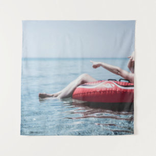 Vrouw op een opblaasbare drijver in de oceaan geri wandkleed
