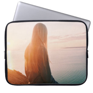 Vrouw staat in de buurt van het waterlichaam tijde laptop sleeve