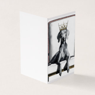 Weimaraner draagt een kroon zittend op een stoel kaart