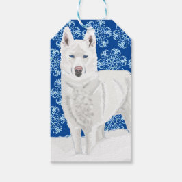 White Husky tegen sneeuwvlokken en donkerblauwe he Cadeaulabel