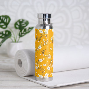 Witte bloem wijnstok op goud waterfles