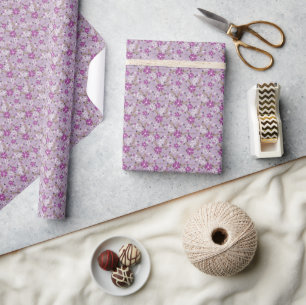Witte en paarse bloemen op een lichtpaarse achterg cadeaupapier