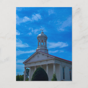 Witte historische kerk met torenspits blauwe lucht briefkaart