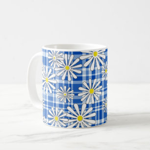 Witte kamillebloemen op een blauwe geruite achterg koffiemok