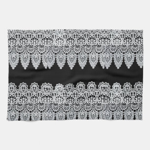 Witte kant vormt een delicate grens tegen zwart theedoek