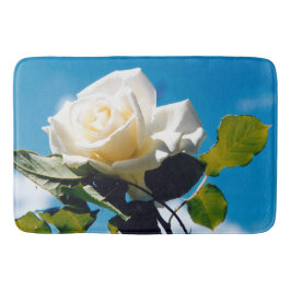 Witte roos onder blauwe hemel badmat