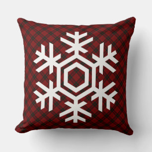 Witte sneeuwvlok op een klassiek rood tartanpatroo kussen