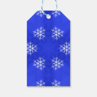 Witte sneeuwvlokken helderblauwe achtergrond cadeaulabel