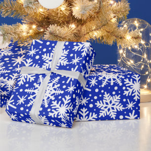 Witte sneeuwvlokken op blauw cadeaupapier