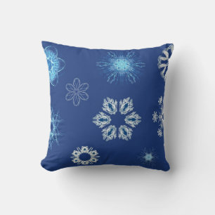 Witte sneeuwvlokken op blauw kussen