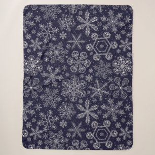 Witte sneeuwvlokken op blauw sherpa deken