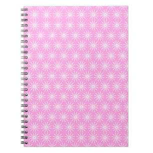 Witte stervormige bloemen op roze notitieboek