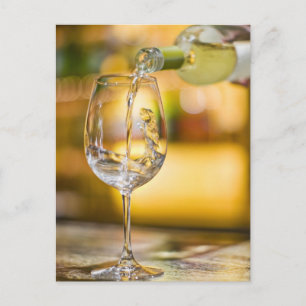 Witte wijn wordt uit de fles gegoten in het restau briefkaart