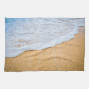Zandstrand met schuimende branding theedoek