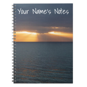 Zee zonnestralen die door de wolken breken notitieboek