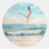 Zeemeeuwen die op een strand vliegen ronde sticker (Voorkant)