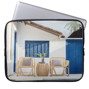 Zelfklevende tafel en twee stoelen in de buurt van laptop sleeve