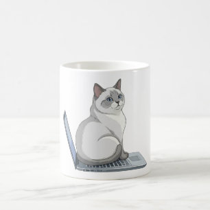 Zittende kat op laptop toetsenbord Schattige werkk Koffiemok