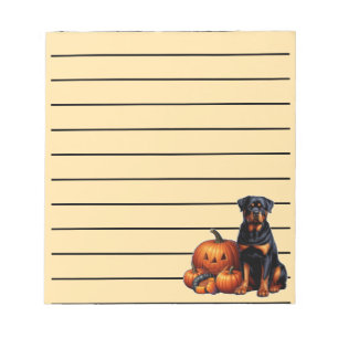 Zittende Rottweiler-hond naast Halloweenpompoenen Notitieblok