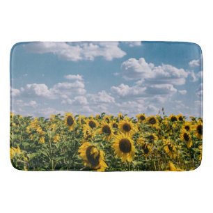 Zonnebloemveld onder blauwe lucht met wolken badmat