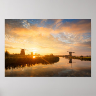Zonneopstand boven windmolens en een rivier in Ned Poster