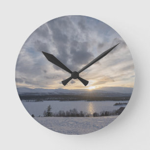 Zonneover bevroren meer ronde klok