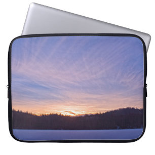 Zonneplaat over met sneeuw bedekt wintermeer en bo laptop sleeve