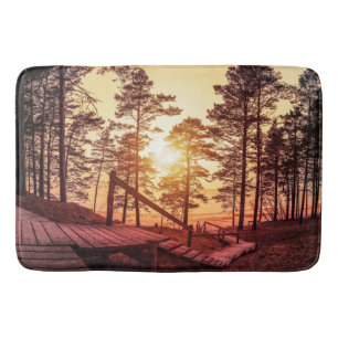 Zonnestralen over houten pad in dennenbos badmat