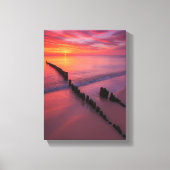 Zonsondergang over het strand met houten palen canvas afdruk (Voorkant)