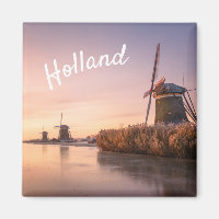 Zonsopkomst over bevroren rivier met windmolens en
