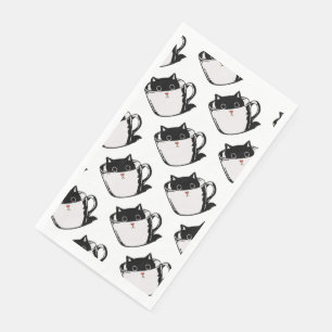 Zwart katje met rode neus verstopt in een kopje servet