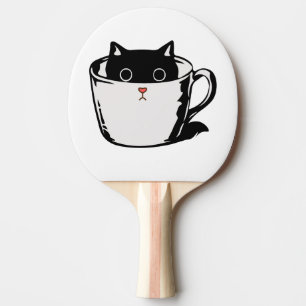 Zwart katje met rode neus verstopt in een kopje tafeltennisbatje