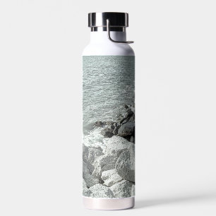 Zwart-wit Foto van een Rocky Ocean Shore Waterfles