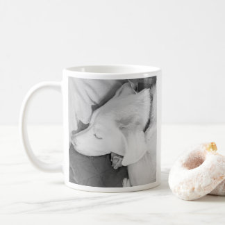 Zwart-wit foto van mooie witte hond slapend koffiemok