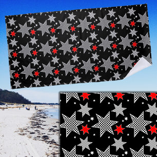 Zwart wit gecheckte strips en rode sterren op zwar strandlaken