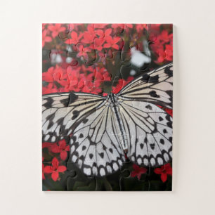 Zwarte en witte vlinder op rode bloemen legpuzzel