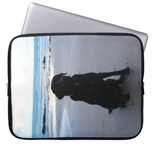Zwarte labrador op een strand laptop sleeve