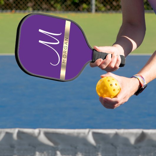 Zwarte naam op gouden band en groot wit monogram pickleball paddle (Insitu)